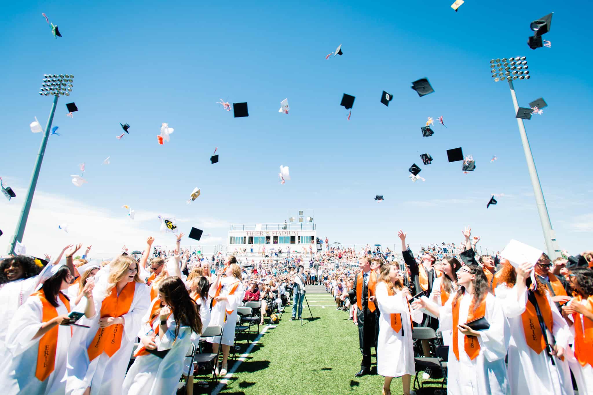 students tossing caps at graduation