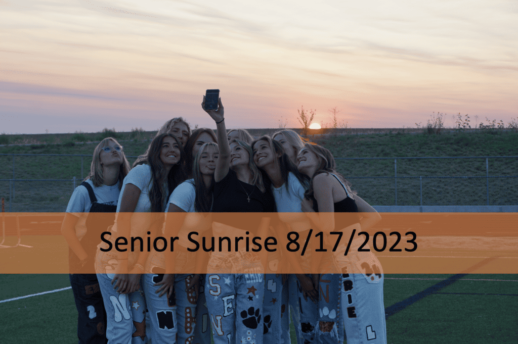 picture of students taking a selfie in front of a sunset